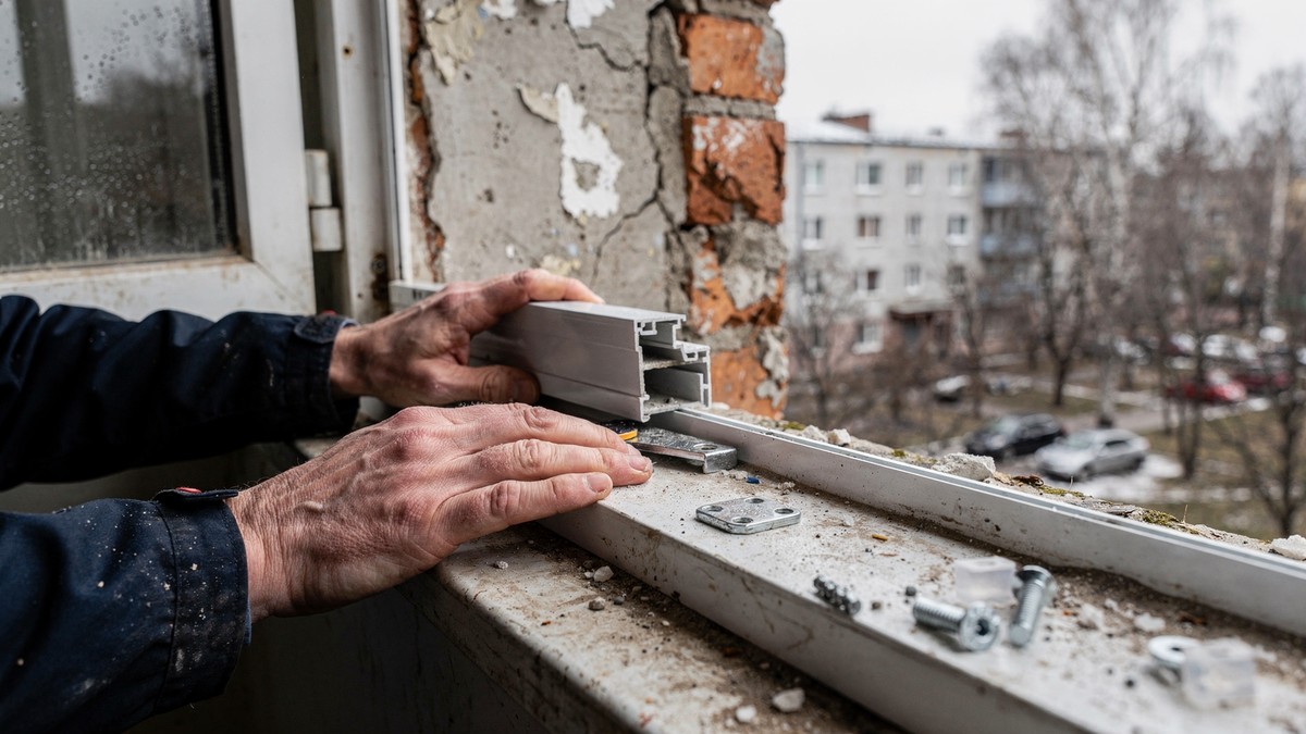 Монтажник устанавливает тёплый профиль Rehau на балконе хрущёвки в Ленинском районе