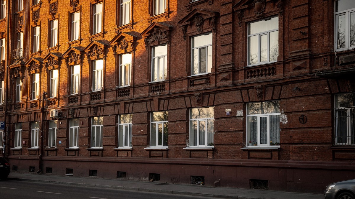 вид на сталинку в Ленинском районе Ярославля, пластиковые окна с белыми рамами на фоне кирпичного фасада